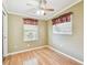 Inviting bedroom with hardwood floors, two windows with valances, and a ceiling fan for comfort at 516 Northmoor N Ave, St Petersburg, FL 33702