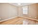 Cozy bedroom with neutral walls and hardwood floors, complemented by a ceiling fan and a sunlit window at 516 Northmoor N Ave, St Petersburg, FL 33702