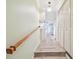 Hallway with a wooden handrail, laminated floors, a ceiling light, and closet doors on the right side at 516 Northmoor N Ave, St Petersburg, FL 33702