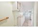 Hallway featuring laminated floors, white cabinets, and a wooden handrail on the left side at 516 Northmoor N Ave, St Petersburg, FL 33702
