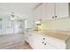 Eat-in kitchen featuring white cabinets, a window, and modern laminated floors throughout the space at 516 Northmoor N Ave, St Petersburg, FL 33702