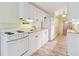 Kitchen features white appliances, laminated floors, and white cabinets offering ample storage at 516 Northmoor N Ave, St Petersburg, FL 33702