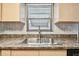 Close-up of kitchen sink and counter, featuring modern faucet, mosaic backsplash, and natural wood cabinets at 516 Northmoor N Ave, St Petersburg, FL 33702