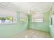 Cozy sunroom with tiled floors, three windows, a ceiling fan, and white trim throughout at 516 Northmoor N Ave, St Petersburg, FL 33702
