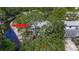 Aerial view of a quaint home surrounded by lush trees, with a canal nearby, and a cozy in-ground pool at 5323 73Rd N St, St Petersburg, FL 33709