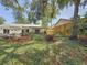 A fenced backyard features a variety of greenery and a small covered patio, providing a private outdoor retreat at 5323 73Rd N St, St Petersburg, FL 33709