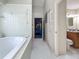 Bright bathroom featuring tiled floors, a tub, and a separated vanity at 5323 73Rd N St, St Petersburg, FL 33709