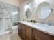 Modern bathroom with double sinks, marble countertops, walk-in shower with glass door at 5323 73Rd N St, St Petersburg, FL 33709
