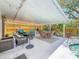 Relaxing covered patio with dining and seating areas, grill, and views of the pool at 5323 73Rd N St, St Petersburg, FL 33709