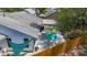 Aerial view of a home with a modern pool area covered by a sun sail, all enclosed by a wooden fence at 5323 73Rd N St, St Petersburg, FL 33709