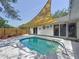Backyard pool with a sunshade, offering a refreshing and private oasis for relaxation and recreation at 5323 73Rd N St, St Petersburg, FL 33709
