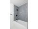 Close-up of the modern bathroom gray tile shower with sleek fixtures and tub at 6304 S S Grady Ave, Tampa, FL 33616