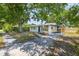 Charming single-story home with a covered parking area and mature trees, offering shade and curb appeal at 6304 S S Grady Ave, Tampa, FL 33616