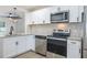 Well-lit kitchen showcasing stainless steel appliances and granite countertops, with white cabinets at 6304 S S Grady Ave, Tampa, FL 33616
