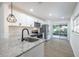 Bright kitchen featuring stainless steel appliances, white cabinetry, and granite countertops at 6304 S S Grady Ave, Tampa, FL 33616