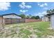 Wide backyard view showcasing a traditional fence, ample green space, and a shed structure at 8445 Angela Ct, Zephyrhills, FL 33541