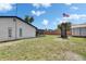 Spacious backyard featuring a well-maintained lawn, a back porch, and a storage building at 8445 Angela Ct, Zephyrhills, FL 33541