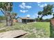 Backyard view showcasing the back of the house with a screened porch and large, mature trees at 8445 Angela Ct, Zephyrhills, FL 33541