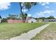 Expansive backyard with a lush lawn, mature trees, a classic fence, and a storage building at 8445 Angela Ct, Zephyrhills, FL 33541
