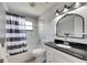 Bathroom featuring shower/tub combo, window, white tile and black granite countertop at 8445 Angela Ct, Zephyrhills, FL 33541