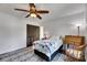 Bedroom featuring ceiling fan, wooden desk, and a large closet at 8445 Angela Ct, Zephyrhills, FL 33541