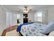 Bedroom view with doorway to bathroom, window and hardwood floors, ceiling fan and TV at 8445 Angela Ct, Zephyrhills, FL 33541