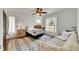 Bright bedroom with hardwood floors, ceiling fan, and a large window view at 8445 Angela Ct, Zephyrhills, FL 33541