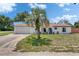 Charming home featuring a well-manicured front yard, a palm tree, and an attached two-car garage at 8445 Angela Ct, Zephyrhills, FL 33541