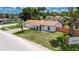 Well-kept single-story home with a palm tree and a paved driveway and mature landscaping at 8445 Angela Ct, Zephyrhills, FL 33541