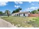 Well-maintained single-story home featuring white stucco, a brown roof, and an attached garage at 8445 Angela Ct, Zephyrhills, FL 33541