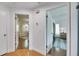 Hallway with multiple doorways leading to rooms with hardwood floors and neutral walls at 8445 Angela Ct, Zephyrhills, FL 33541
