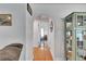 Hallway with light colored walls, wood floors and archway leading to bedroom at 8445 Angela Ct, Zephyrhills, FL 33541