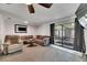 Comfortable living room features plush seating, ceiling fan and sliding glass doors to patio at 8445 Angela Ct, Zephyrhills, FL 33541