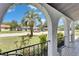 Inviting front porch with decorative arches offering a neighborhood view, framed by greenery at 8445 Angela Ct, Zephyrhills, FL 33541
