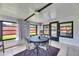 Sunroom with tile floors, comfortable seating, multiple windows providing ample natural light and backyard views at 8445 Angela Ct, Zephyrhills, FL 33541