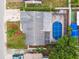 Aerial view of the house featuring a pool with metal enclosure and landscaped backyard, showing the overall layout of the property at 9011 Hunt Club Ln, Port Richey, FL 34668
