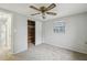 Bright bedroom featuring a ceiling fan, closet, and a window providing natural light at 9011 Hunt Club Ln, Port Richey, FL 34668