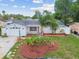 Charming home featuring well-maintained landscaping with palm trees and a bright white exterior at 9011 Hunt Club Ln, Port Richey, FL 34668