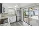 Bright kitchen featuring stainless steel appliances, white cabinetry, subway tile backsplash, and sliding doors to patio at 9011 Hunt Club Ln, Port Richey, FL 34668