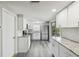 Well-appointed kitchen with modern appliances, white cabinetry, and stylish finishes, offering a functional and appealing space at 9011 Hunt Club Ln, Port Richey, FL 34668
