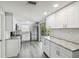 Modern kitchen featuring white cabinets, stainless steel appliances, granite countertops, and subway tile backsplash at 9011 Hunt Club Ln, Port Richey, FL 34668