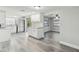 Bright kitchen with white cabinets, stainless steel appliances, and stylish subway tile backsplash, seamlessly connected to the living area at 9011 Hunt Club Ln, Port Richey, FL 34668