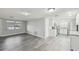Open concept living and kitchen area with white cabinets, stainless steel appliances and modern gray flooring at 9011 Hunt Club Ln, Port Richey, FL 34668