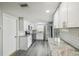 Bright kitchen with stainless steel appliances, white cabinetry, granite countertops, and access to a side door at 9011 Hunt Club Ln, Port Richey, FL 34668