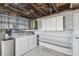 Functional laundry room with washer, dryer, water heater, storage shelves and cabinets at 9011 Hunt Club Ln, Port Richey, FL 34668