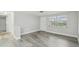 Neutral living area with gray flooring and a view of the natural light from the nearby window at 9011 Hunt Club Ln, Port Richey, FL 34668