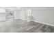 Open concept living area with modern gray flooring, light walls, and seamless flow to the adjacent kitchen at 9011 Hunt Club Ln, Port Richey, FL 34668