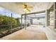 Outdoor covered screened patio area with ceiling fan overlooking the green garden and the pool with lounge chairs at 9011 Hunt Club Ln, Port Richey, FL 34668