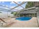 Private pool area with metal screened pool enclosure, lounge chairs, and an inviting space for relaxation at 9011 Hunt Club Ln, Port Richey, FL 34668