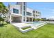 Expansive backyard featuring a modern pool and a well-maintained lawn at 905 Bay Point Dr, Madeira Beach, FL 33708